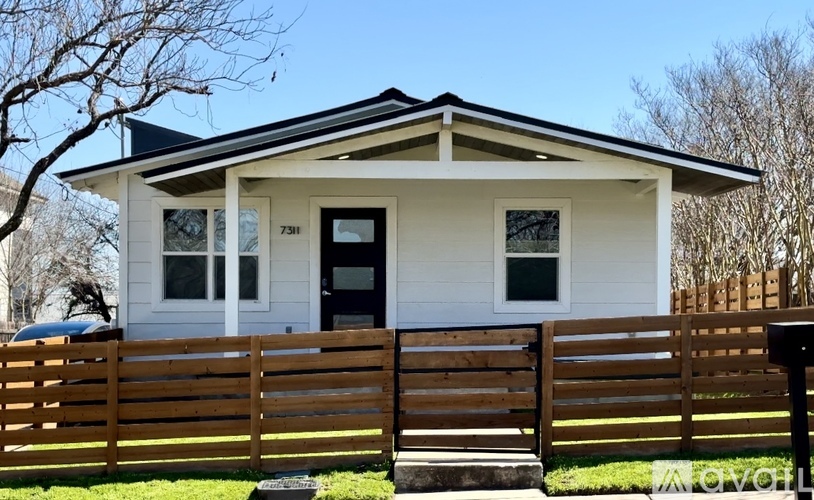 A small white house with a black door and windows.