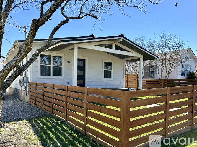 A house with a white exterior and a wooden fence.