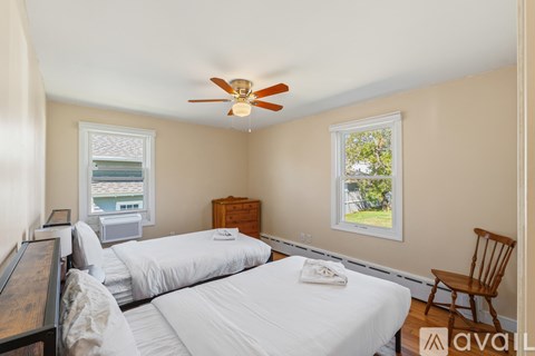A bedroom with two beds and a ceiling fan.