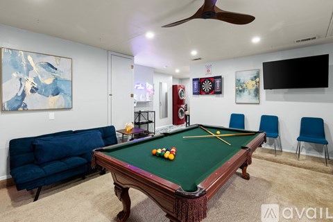 A pool table with a green cloth and a few balls on it.