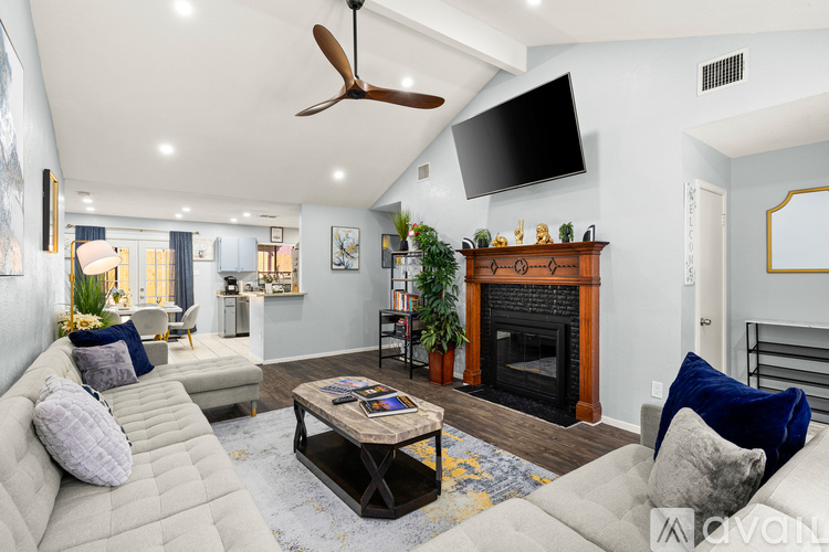 A living room with a fireplace and a television mounted on the wall.