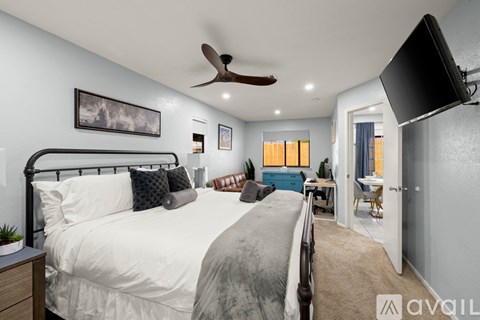 A bedroom with a large bed and a ceiling fan.