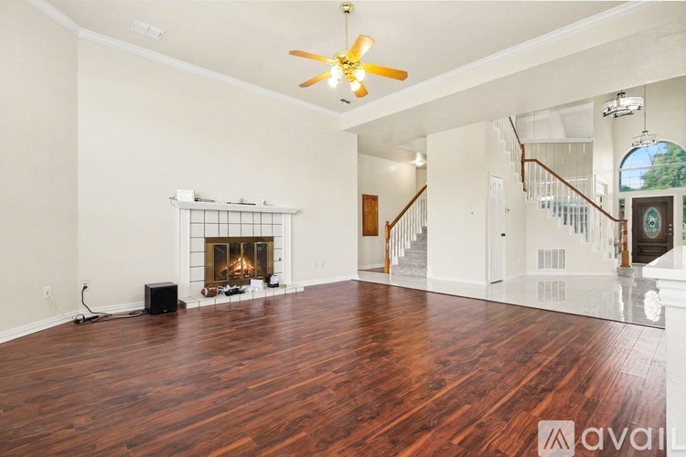 A spacious living room with a fireplace and hardwood floors.