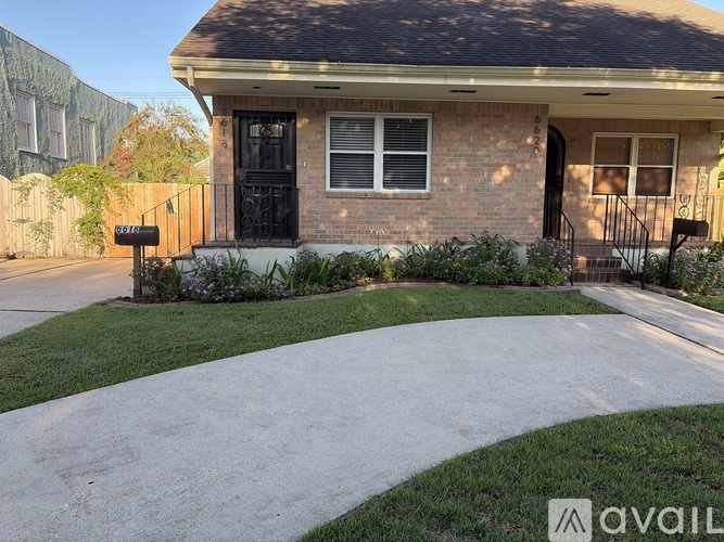 A house with a black door and a mailbox in front.
