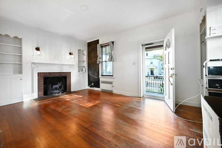 A living room with a fireplace and wood floors.