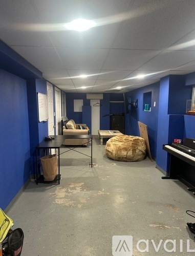 A room with blue walls and a piano in the corner.