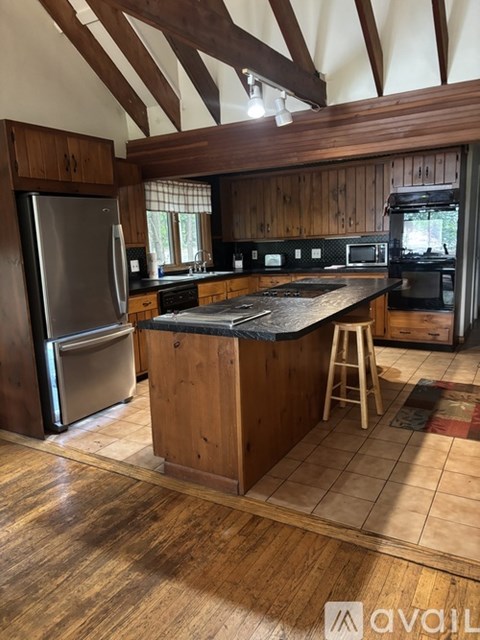 A kitchen with wooden cabinets and a large island.