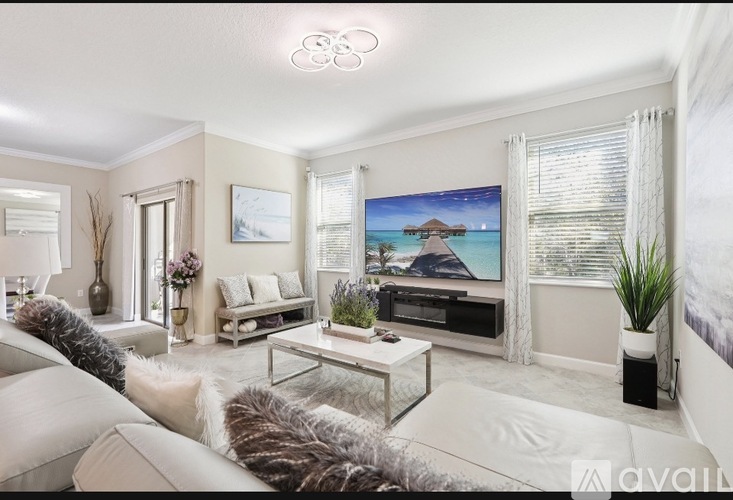 A living room with a white couch and a glass coffee table.
