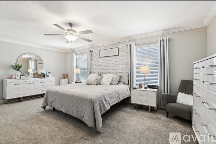A bedroom with a bed, dresser, and chair.