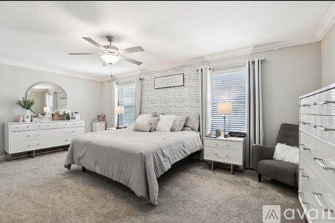A bedroom with a bed, dresser, and chair.