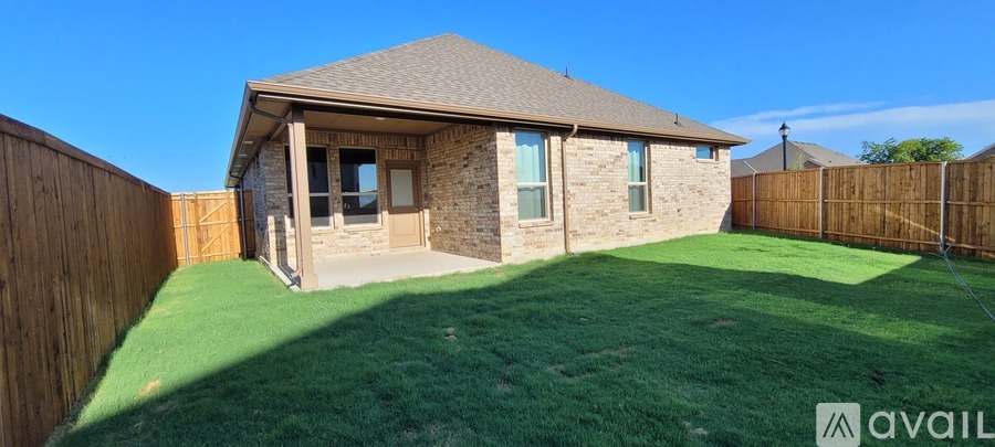 A house with a brown fence and a green lawn.