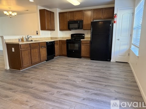 A kitchen with wooden cabinets and black appliances.