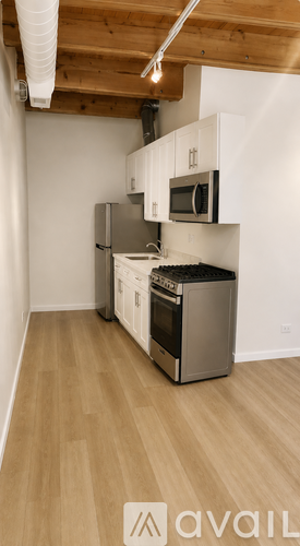 A kitchen with wooden floors and white walls.