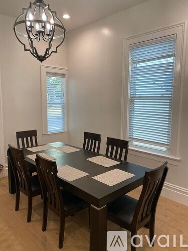 A dining room with a table set for six.