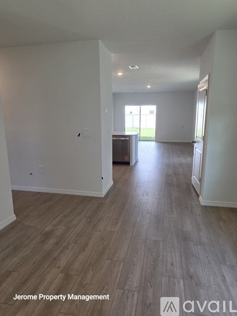 A spacious room with wooden flooring and white walls, managed by Jerome Property Management.