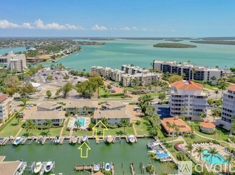 A view of a marina with boats and buildings.