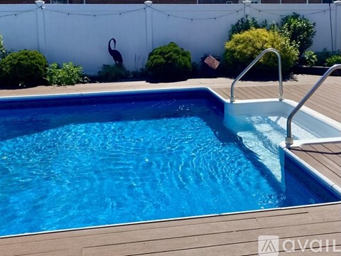 A small pool with a wooden deck and a metal ladder.