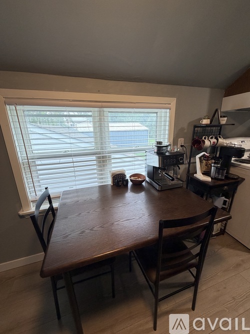A dining room with a wooden table and chairs.