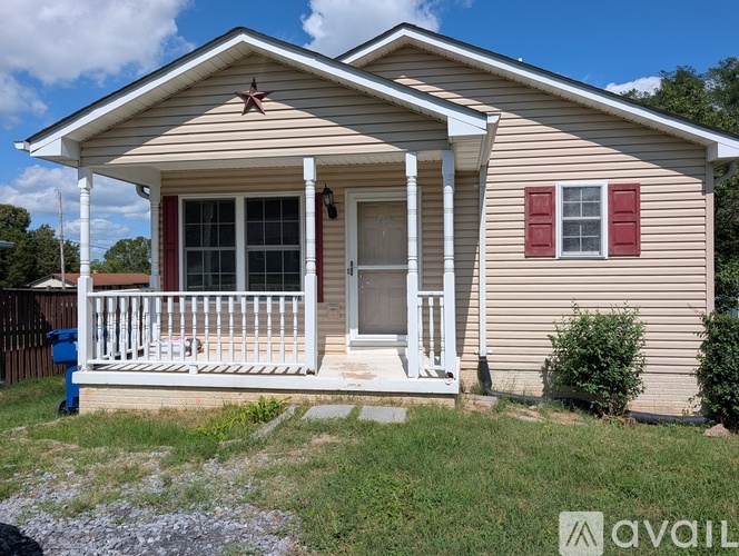 A small house with a porch and a mailbox.