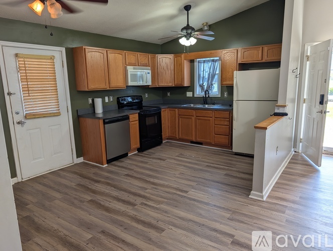 A kitchen with wooden cabinets and a black stove top oven.