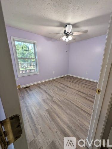 A room with a ceiling fan and a window.