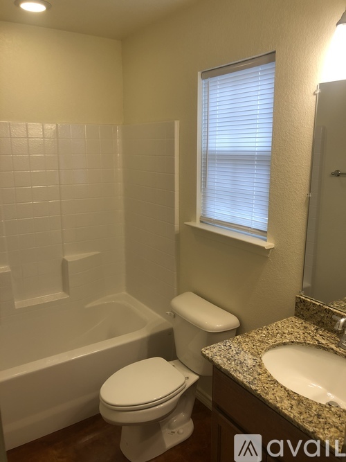A white toilet sits next to a bathtub in a bathroom.