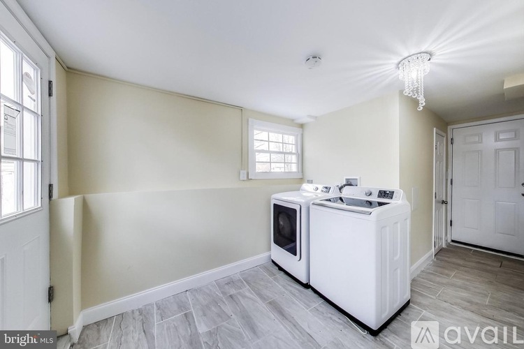 A kitchen area with a white cabinet and a microwave on top.