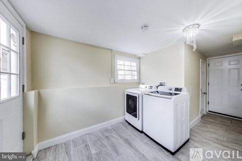 A kitchen area with a white cabinet and a microwave on top.