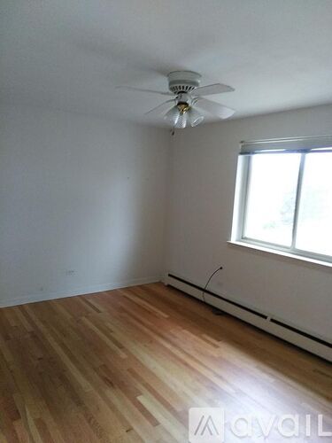 A room with a ceiling fan and a window.