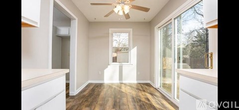 A spacious room with a ceiling fan and sliding glass doors.