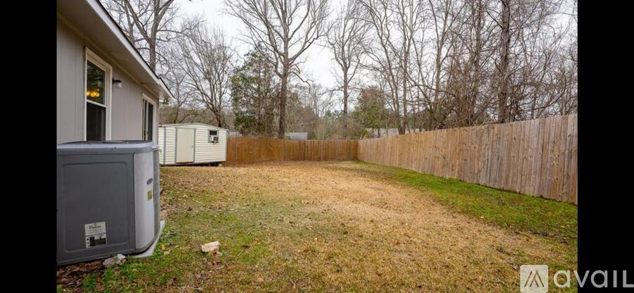 A backyard with a wooden fence and a utility box.