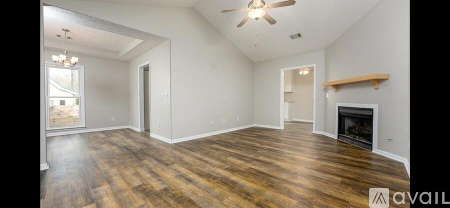 A spacious room with wood flooring and a fireplace.