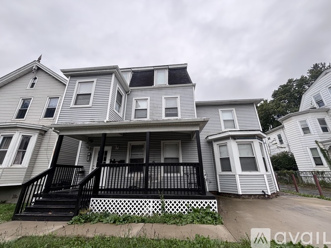 A house with a grey siding and a black railing.