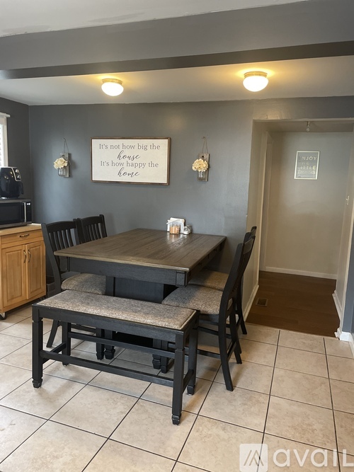 A dining room with a wooden table and chairs.