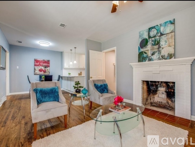 A living room with a fireplace and a painting on the wall.