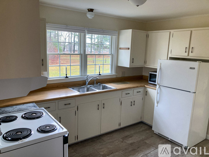 A kitchen with white appliances and cabinets.