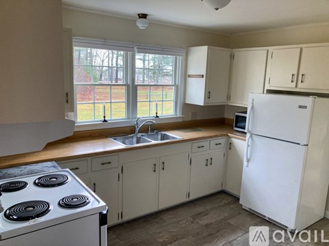 A kitchen with white appliances and cabinets.