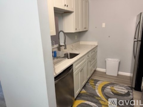 A kitchen with white cabinets and a sink.