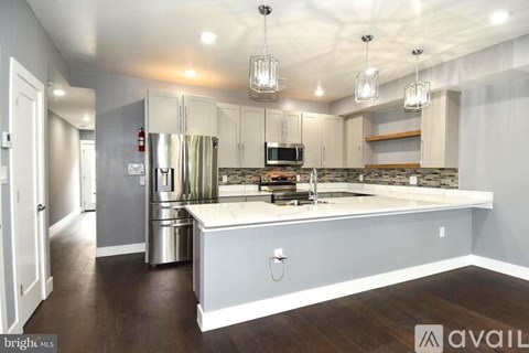 A kitchen with a refrigerator, microwave, and oven is available for rent.