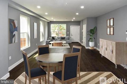 A dining room with a round table and chairs.