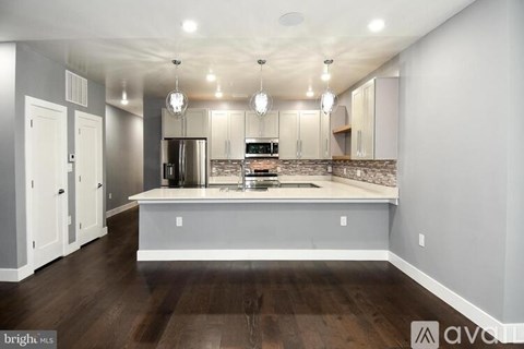 A kitchen with a refrigerator, oven, and cabinets.