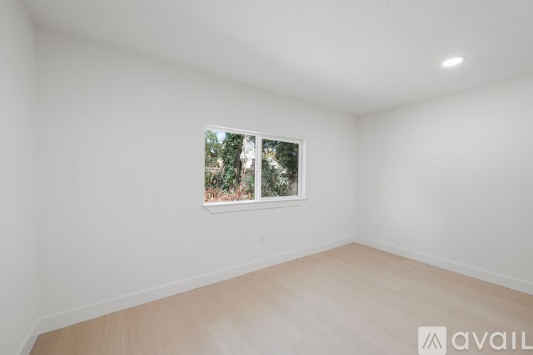 A room with a window showing trees outside.