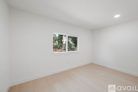 A room with a window showing trees outside.