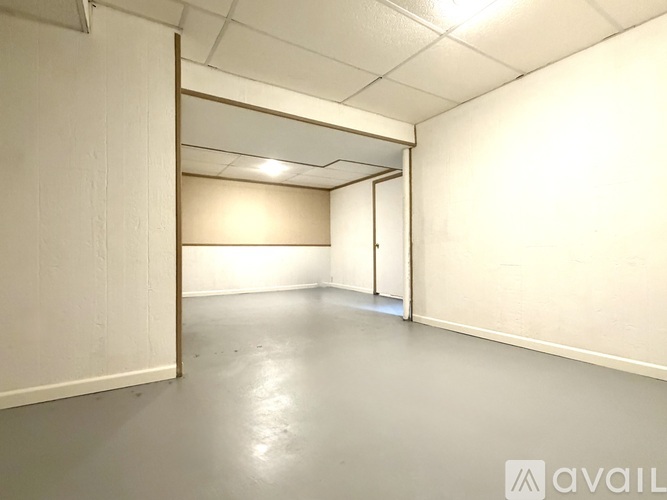 A spacious room with a doorway leading to another room.