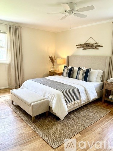 A bedroom with a large bed and a ceiling fan.