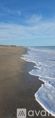 A beach with waves gently lapping at the shore.