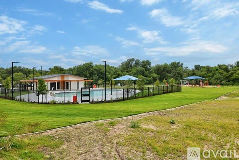 A pool area with a building and umbrellas.