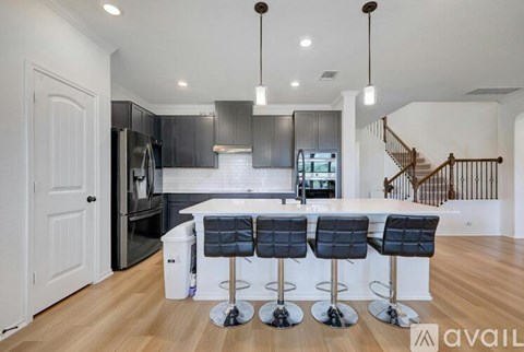 A modern kitchen with a bar stool in front of it.