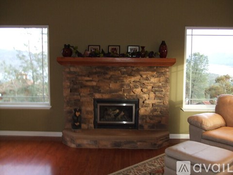 A living room with a stone fireplace and a couch.