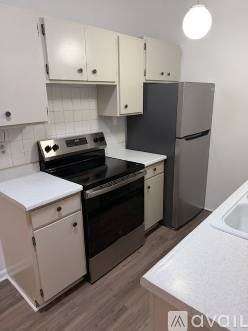 A kitchen with white cabinets and a black stove top oven.
